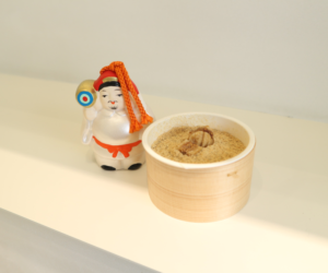 写真：7福神の人形とプリンが並んでいる様子
